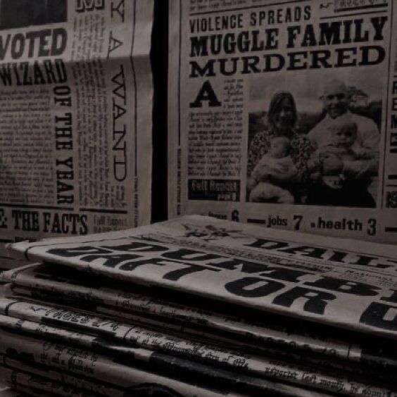 newspapers stacked on top of each other in front of a wall covered with newspaper clippings