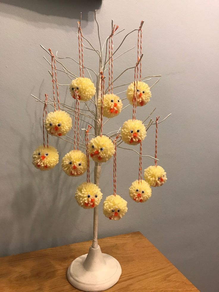 a bunch of pom - poms are hanging from a tree in front of a wall