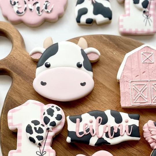 decorated cookies are arranged on a cutting board with farm animals and barn numbers in the background