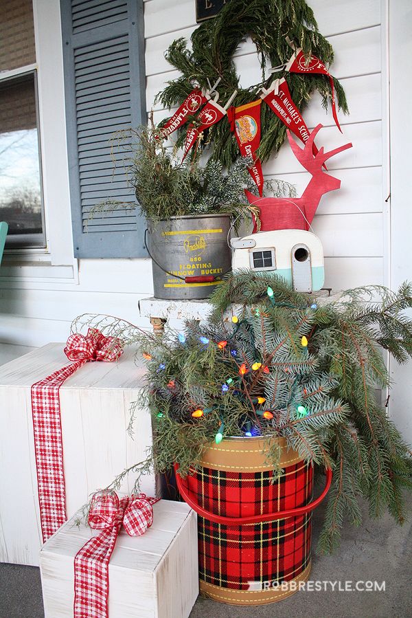 christmas decorations on the front porch with presents in buckets next to it and an antler