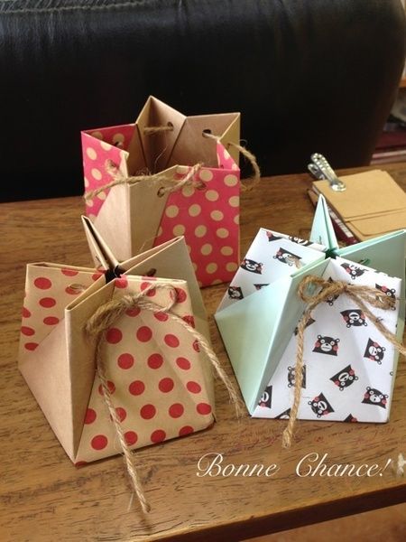 four small gift bags tied with twine on a table in front of a couch