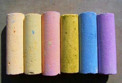 five different colored toilet paper rolls lined up in a row on the ground with shadows coming from them