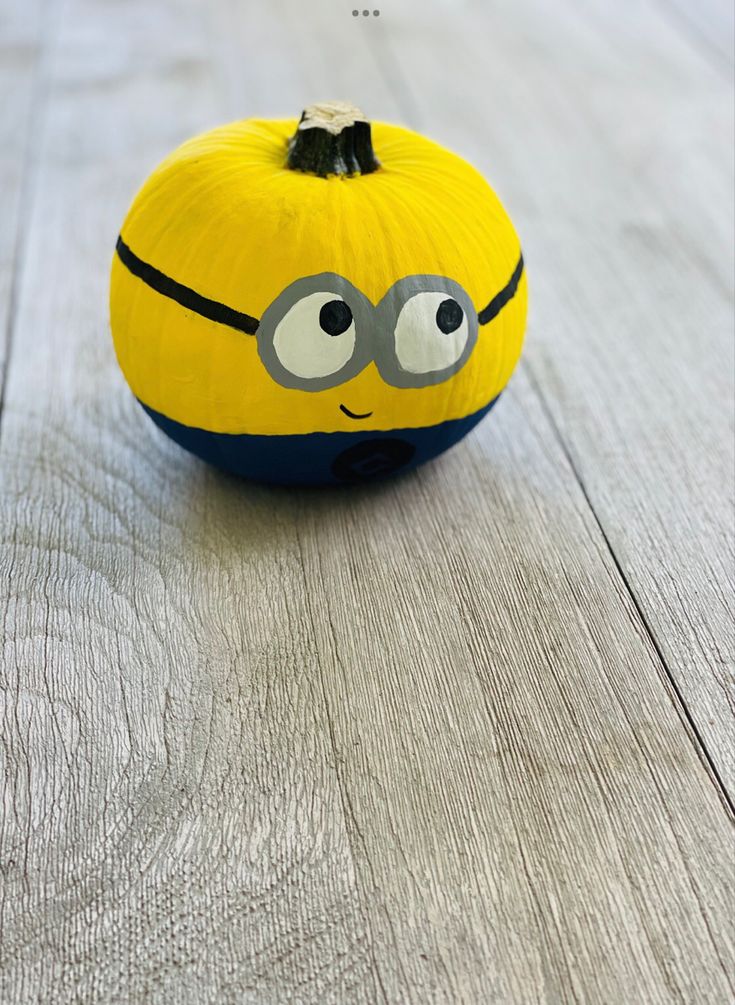 a yellow and blue painted pumpkin with eyes