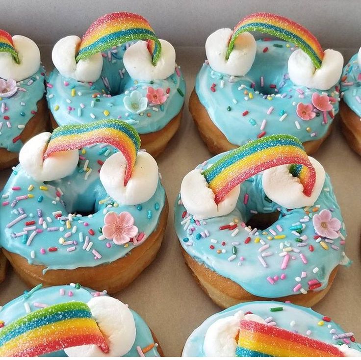 a box filled with donuts covered in frosting and rainbow decorations