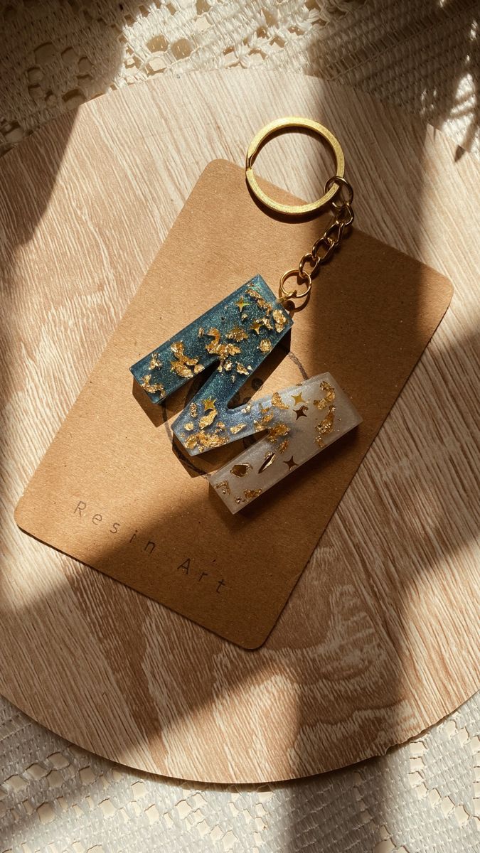 two pieces of wood sitting on top of a piece of paper with a metal keychain