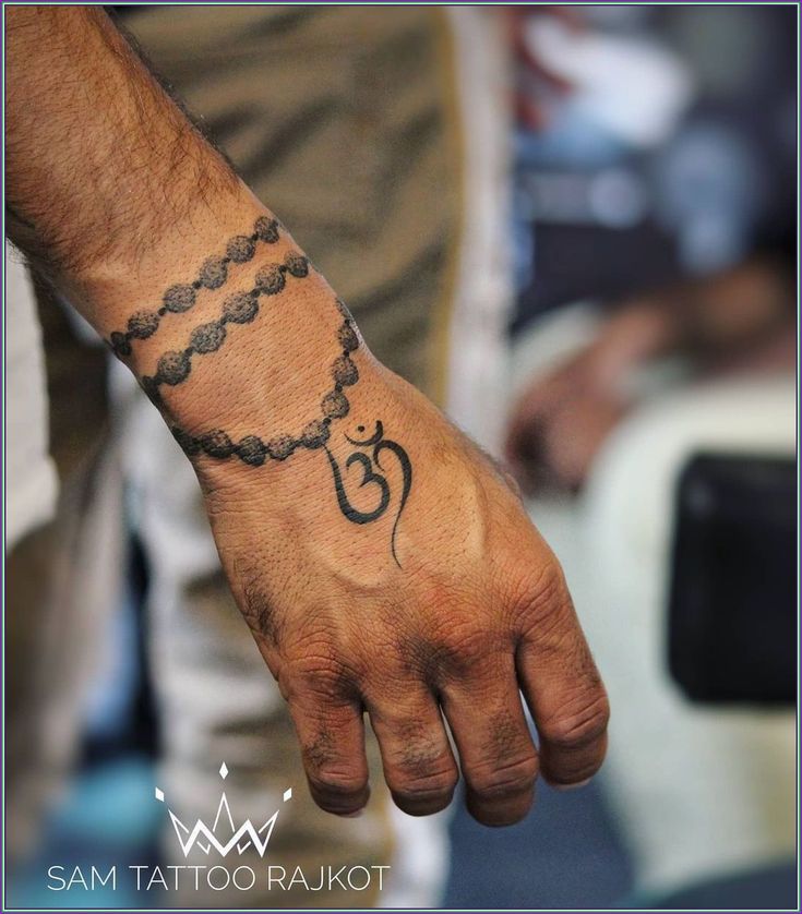 a man with a tattoo on his hand holding onto a string that is attached to the wrist