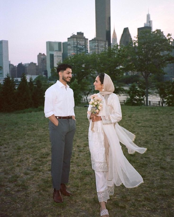 a bride and groom are standing in the grass