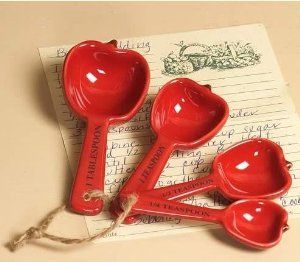 three red measuring spoons sitting on top of a piece of paper next to each other