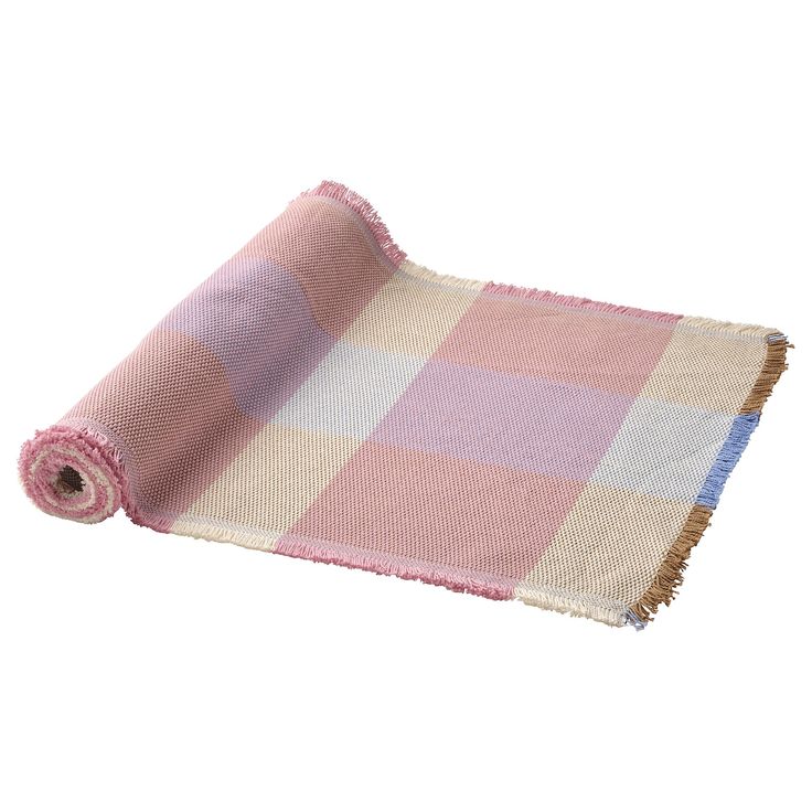 a pink and white checkered blanket folded on top of a roll of cloth with fringes