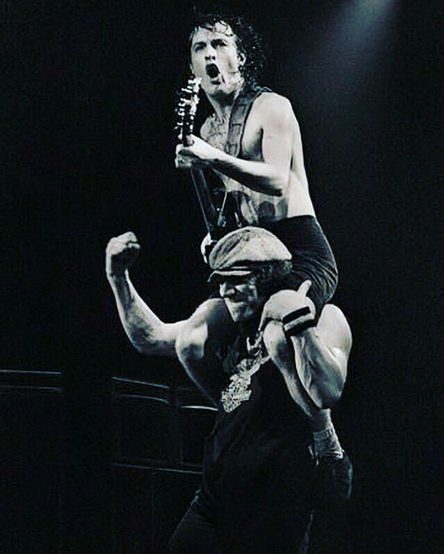 a man holding onto another man on stage