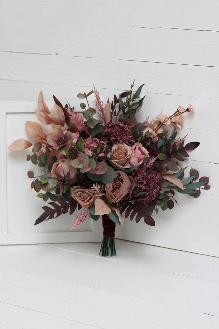 a bridal bouquet with pink and purple flowers on a white doorknoth