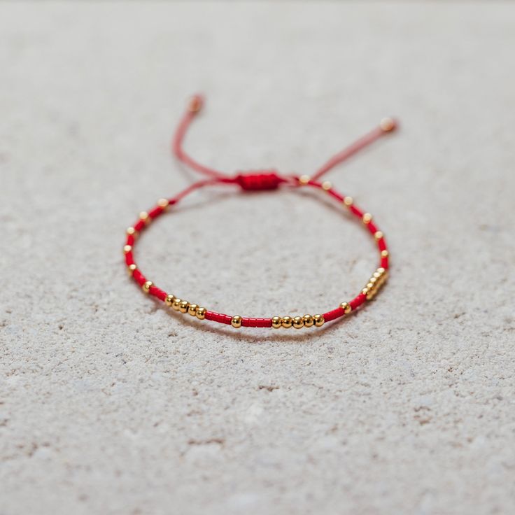 Our Fortune-bracelet is crafted with a red string and an array of gold beads for a radiant look. Each piece is handmade with love by female artisans. It’s said this magnificent bracelet brings luck, fortune, and protection to the wearer. Gold Beaded Bangle Bracelet Gift, Gold Beads Bangle Bracelet Gift, Gold Beaded Bangle Bracelet Perfect For Gifts, Red Adjustable Bracelets For Festivals, Red Gold Jubilee Bracelet For Gift, Red Jubilee Gold Bracelet Gift, Friendship Bracelet With Gold Beads, Handmade Bohemian Yellow Gold Beaded Bracelets, Handmade Yellow Gold Bohemian Beaded Bracelets