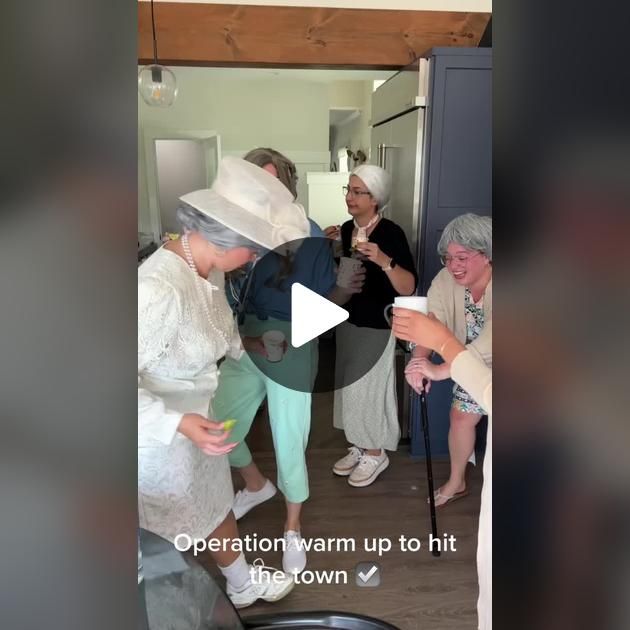 several older women in white dresses and hats are talking to each other while holding cups