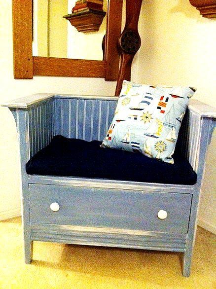 a blue bench sitting in front of a mirror with a pillow on top of it