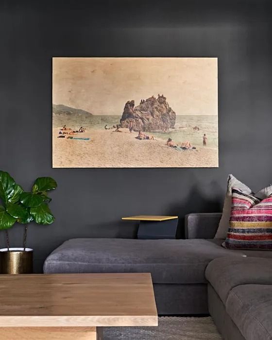 a living room filled with furniture and a painting hanging on the wall over a couch