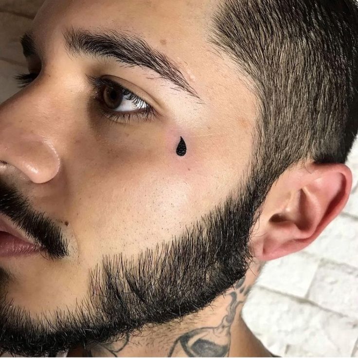 a close up of a man with a beard and piercing on his nose looking at the camera