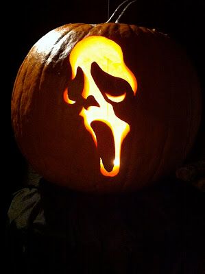 a carved pumpkin with an evil face on it's head and mouth is lit up in the dark