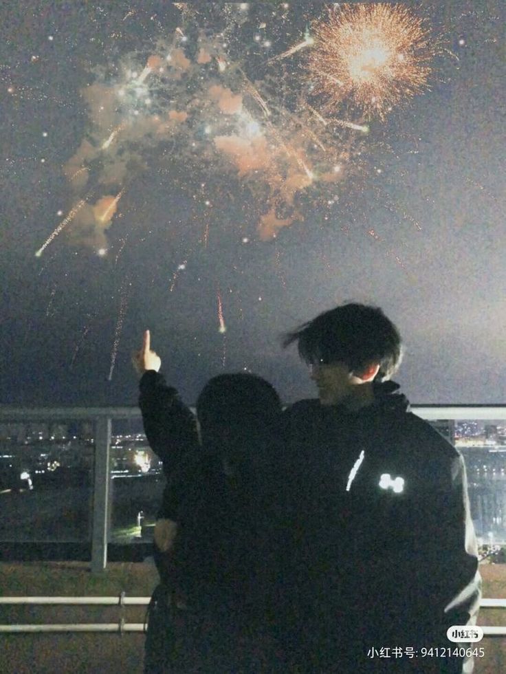 two people looking at fireworks in the sky