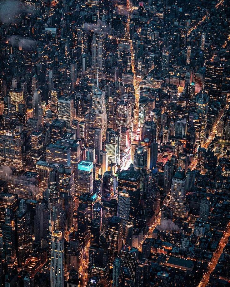 an aerial view of the city at night from above, looking down on skyscrapers