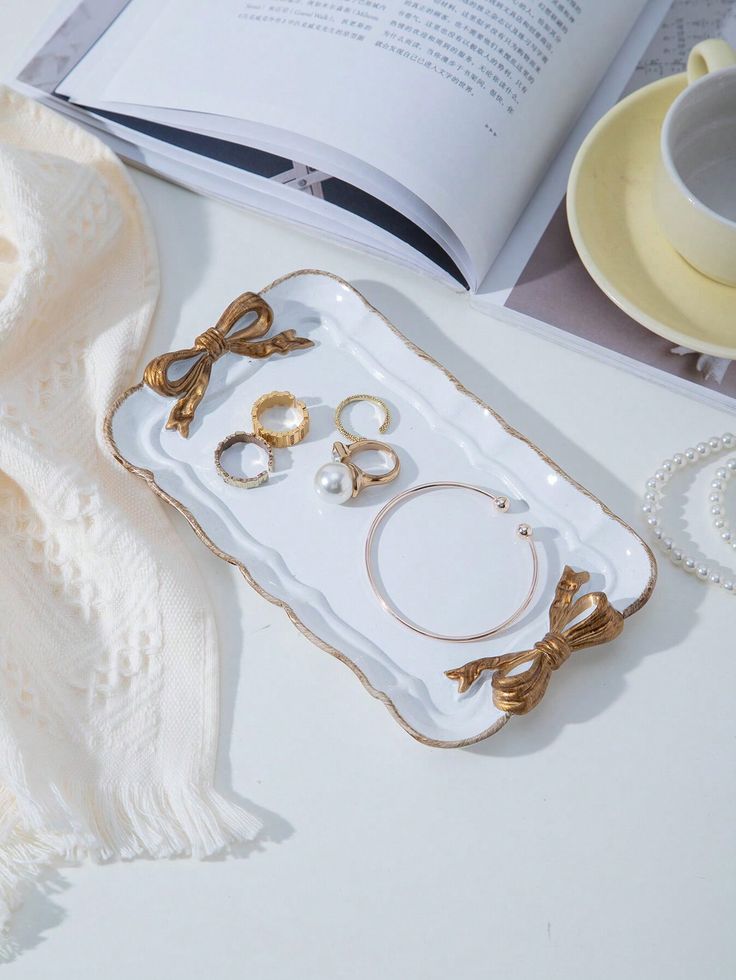 an open book on a table next to jewelry