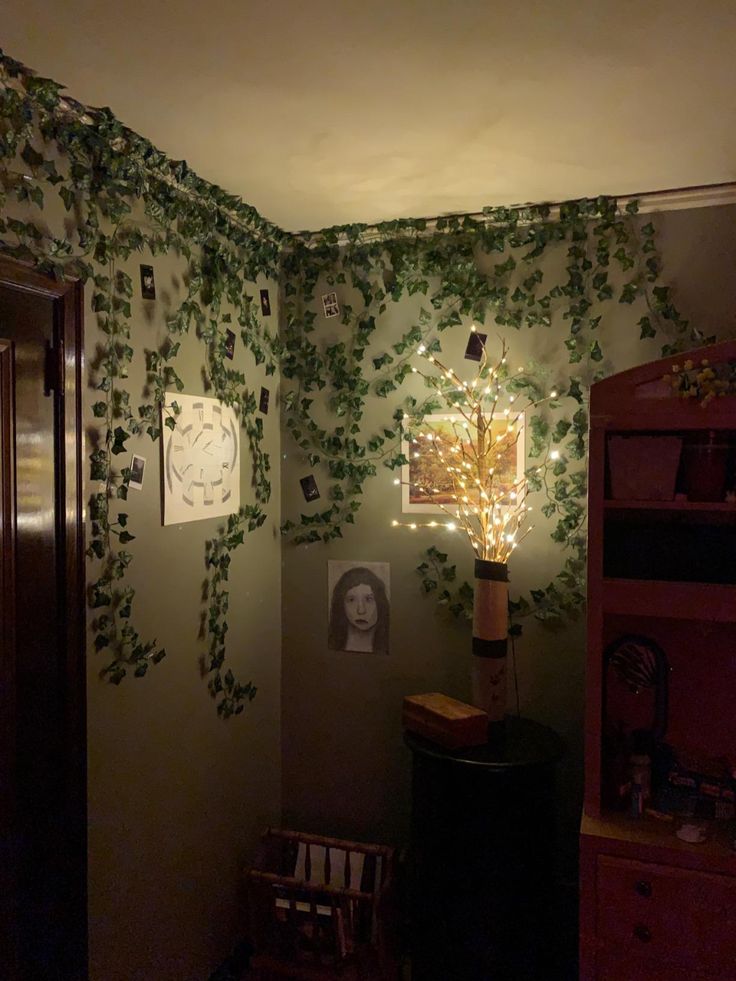 a room with ivy growing on the wall and lights in the corner, along with pictures hanging on the wall