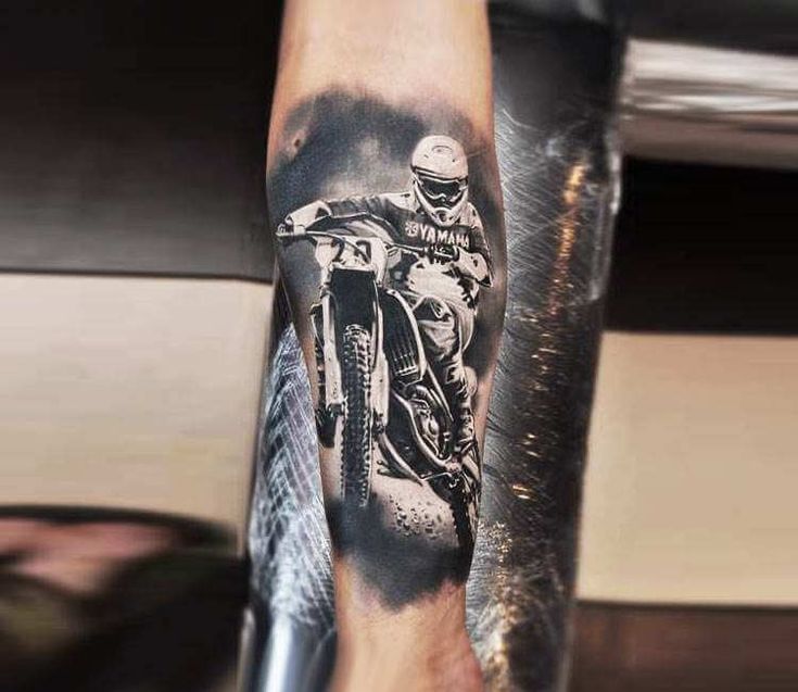 a man's arm with a black and white photo of a motorcyclist on it