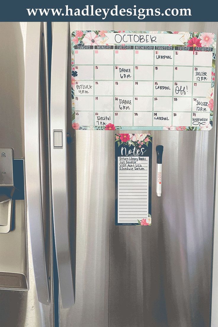 a stainless steel refrigerator with a calendar on the door and magnets attached to it