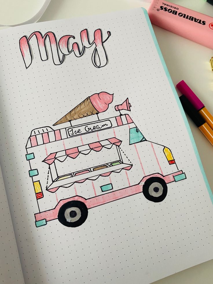 a notebook with an ice cream truck drawn on it and some crayons next to it