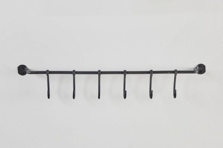 a metal rack with five hooks on it