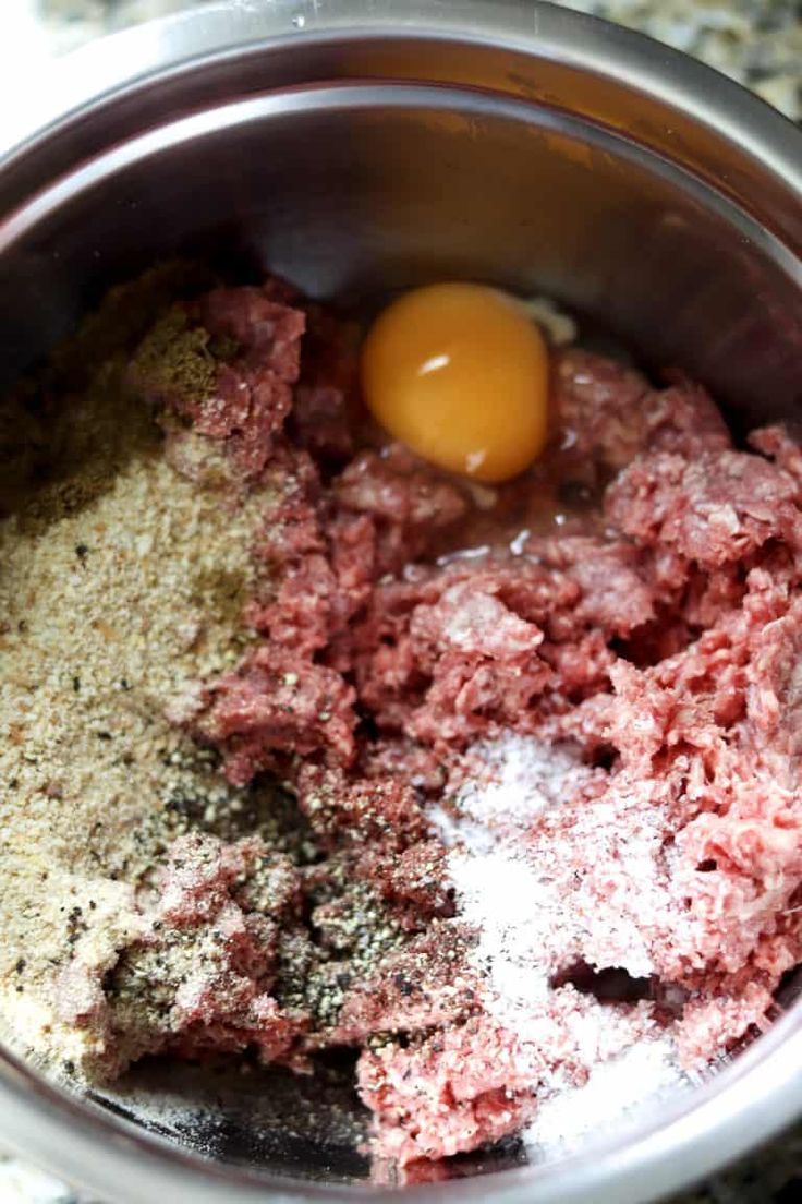 meat and spices in a bowl with an egg