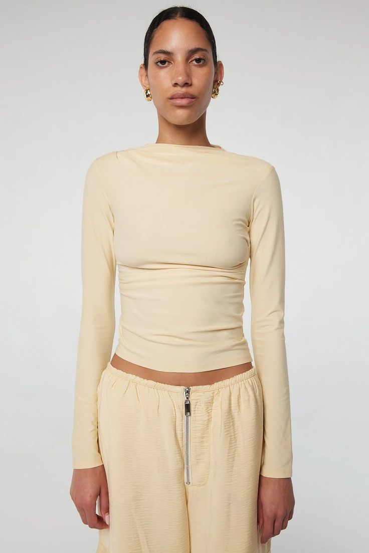 Selma: High neck, slim long sleeves in a cotton-modal blend. Effortless drape with hand-pleated details. 45% Cotton 45% Modal 10% Spandex. Casual Fitted Ruched Long Sleeve Top, Fitted Ruched Long Sleeve Casual Top, Casual Fitted Long Sleeve Ruched Top, Ruched Fitted Long Sleeve Top For Fall, Long Sleeve Top For Spring, Spring Fitted Ruched Long Sleeve Top, Long Sleeve Tops With Thumbholes And Minimal Stretch, Spring Ruched Fitted Long Sleeve Top, Spring Ruched Long Sleeve Fitted Top