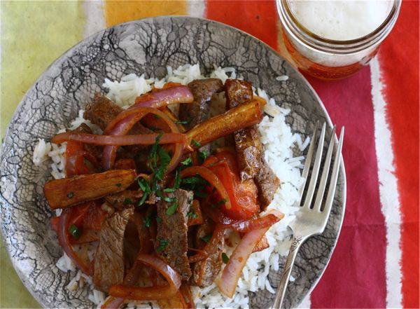 a plate with rice, meat and vegetables on it next to a glass of milk