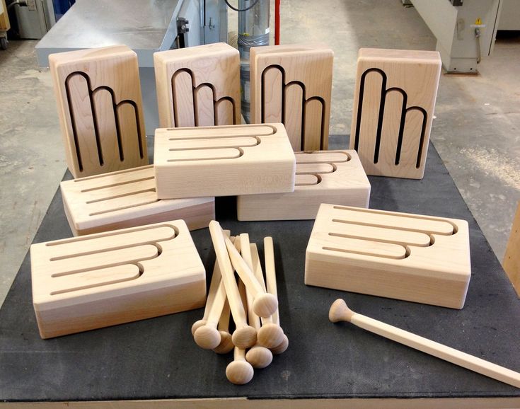 several wooden blocks and mallets are arranged on a table in front of a machine