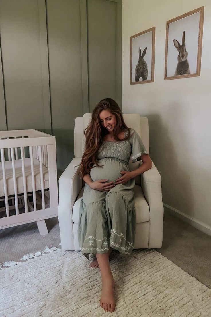 a pregnant woman sitting in a white chair