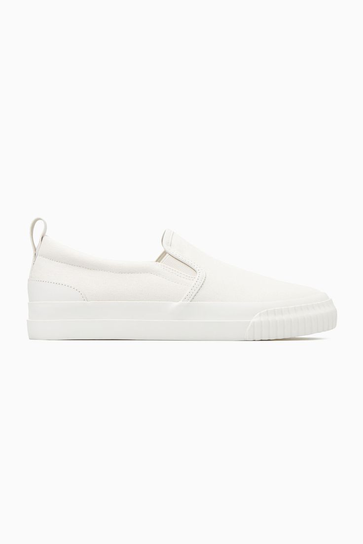 These slip-on trainers are an easy option for summer dressing – they'll go with all your casual outfits but will work equally well to pare back tailoring, too. Crafted from cotton-canvas with leather detailing, they come in versatile white and have chunky rubber soles and elasticated inserts for comfort. The leather pull tab at the back makes them easy to slip on and off. Leather binding and panellingRecycled cotton is made by converting both pre- and post-consumer fabric into fibres that are th Sporty Canvas Slip-on Sneakers For Summer, Cotton Slip-ons With Rubber Sole, Casual White Slip-ons With Contrast Sole, White Slip-on Sneakers For Everyday, Sporty Summer Canvas Slip-on Sneakers, Sporty Slip-on Sneakers For Everyday Summer Use, White Canvas Slip-ons For Summer, White Slip-on Sneakers With Rubber Waffle Outsoles, Sporty Summer Canvas Slip-ons