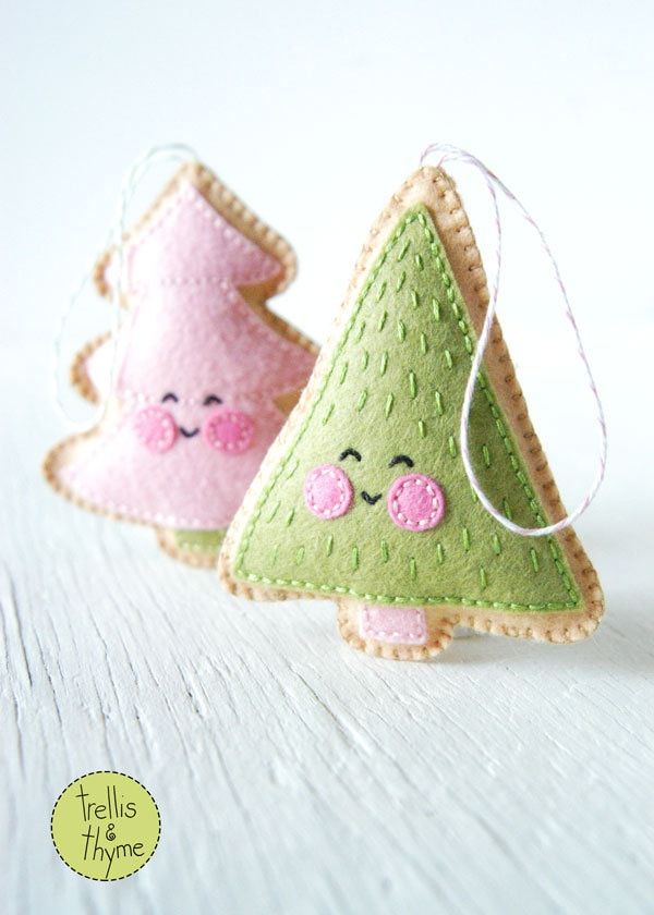 two small felt christmas trees with faces on them, one is green and the other is pink