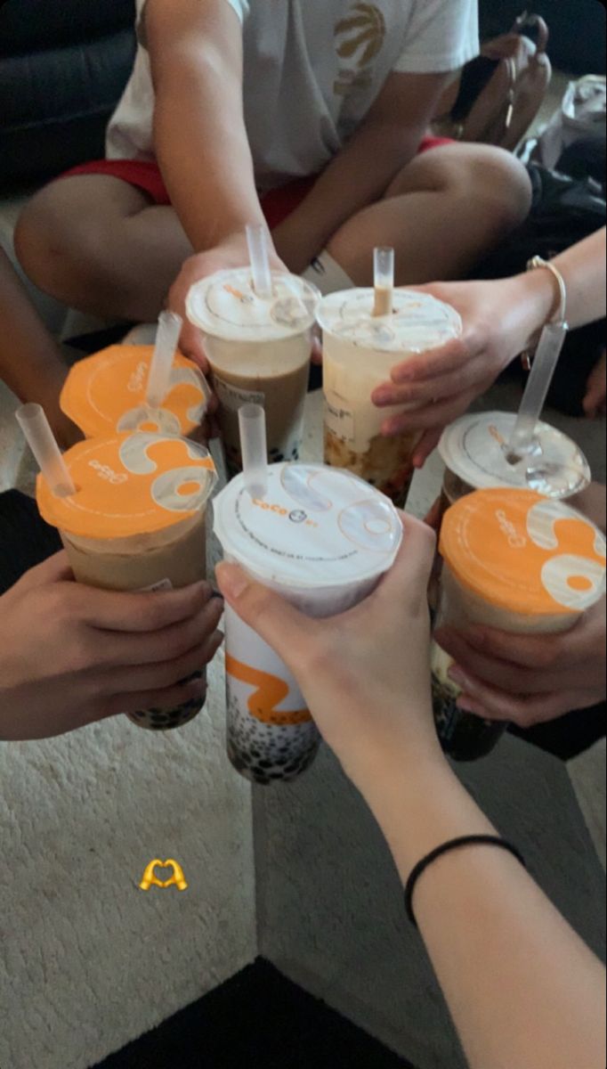 several people are holding cups with drinks in them and one person is reaching for the cup