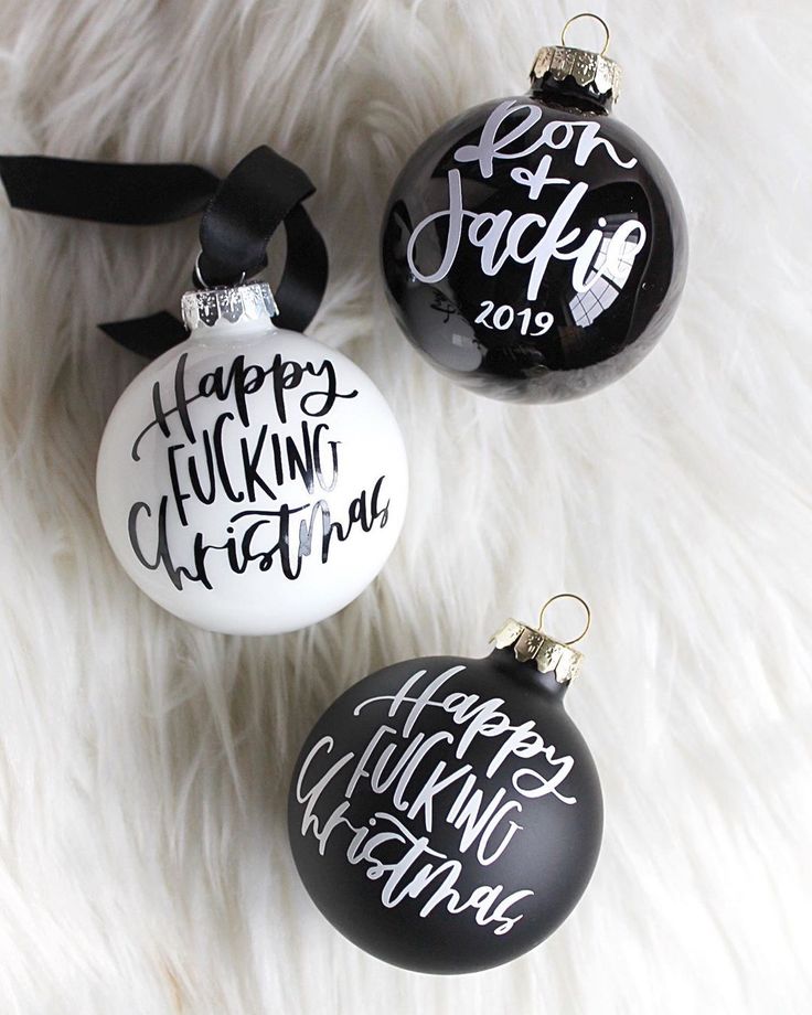 three black and white christmas ornaments with hand lettering