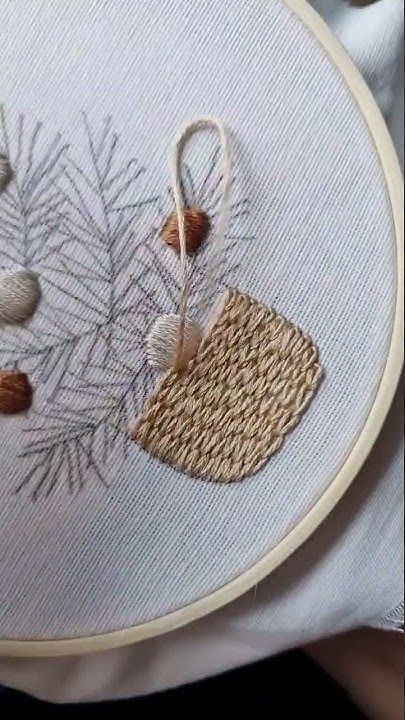 a close up of a person holding a piece of embroidery