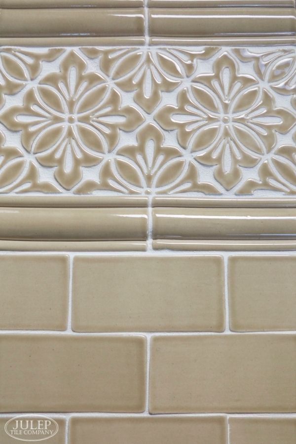 a close up view of a tile wall with flowers on the bottom and side panels