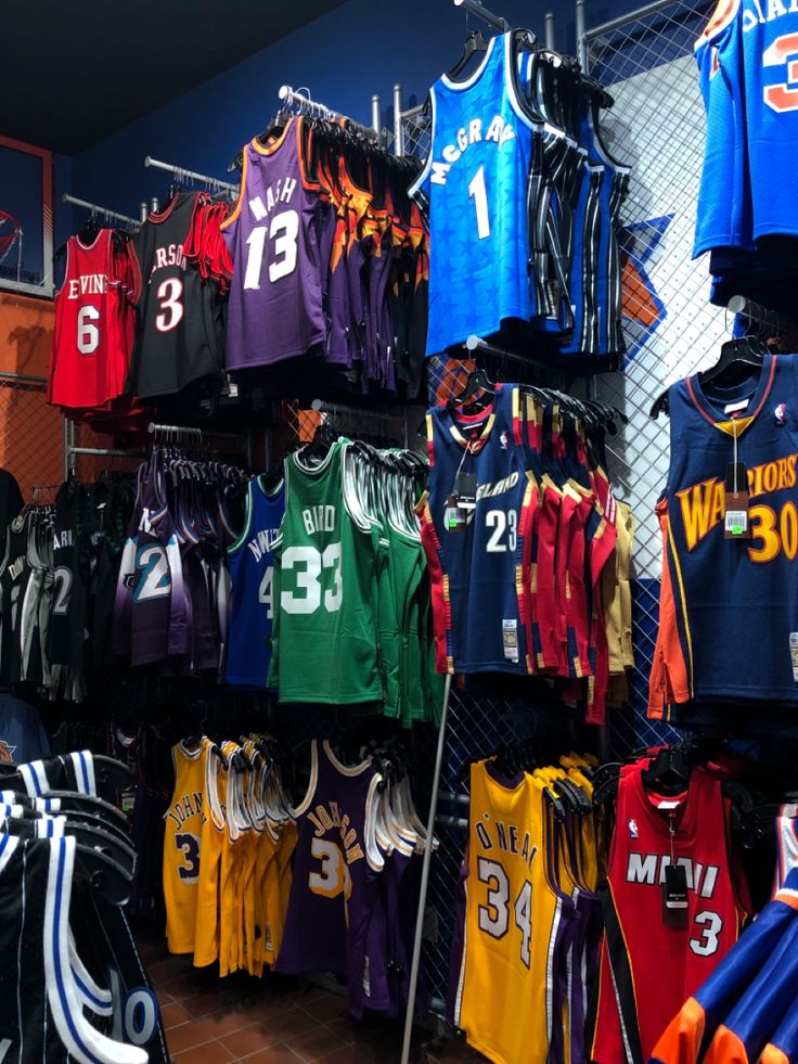 many basketball jerseys are on display in a store