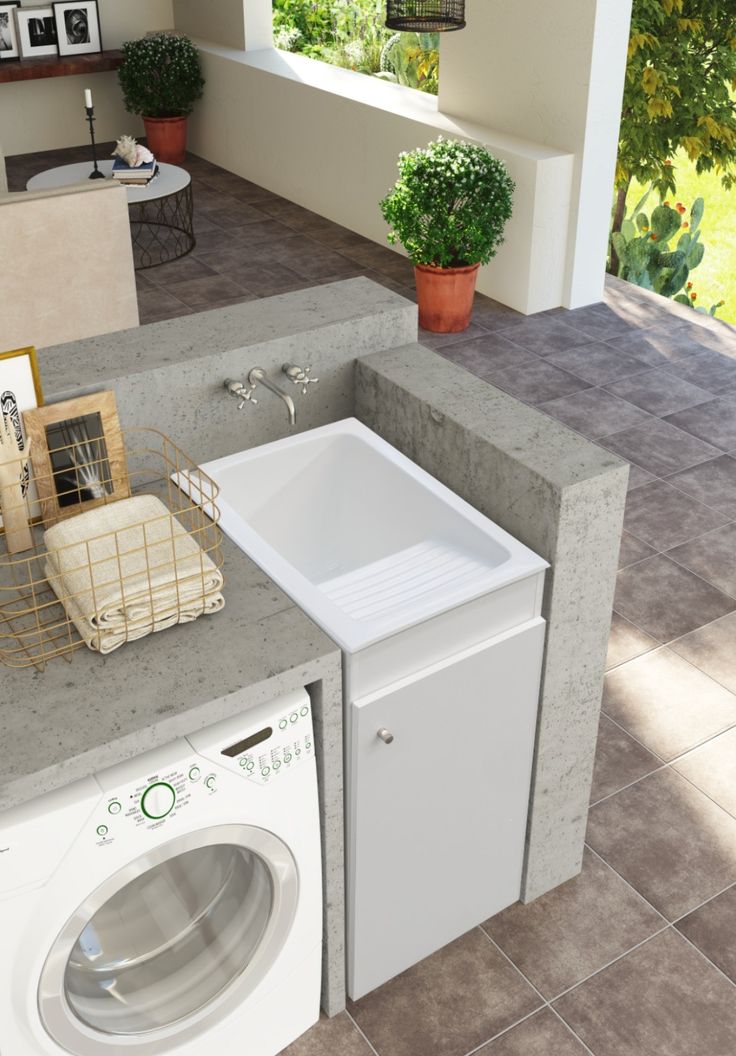 a white sink sitting next to a washer and dryer on top of a counter