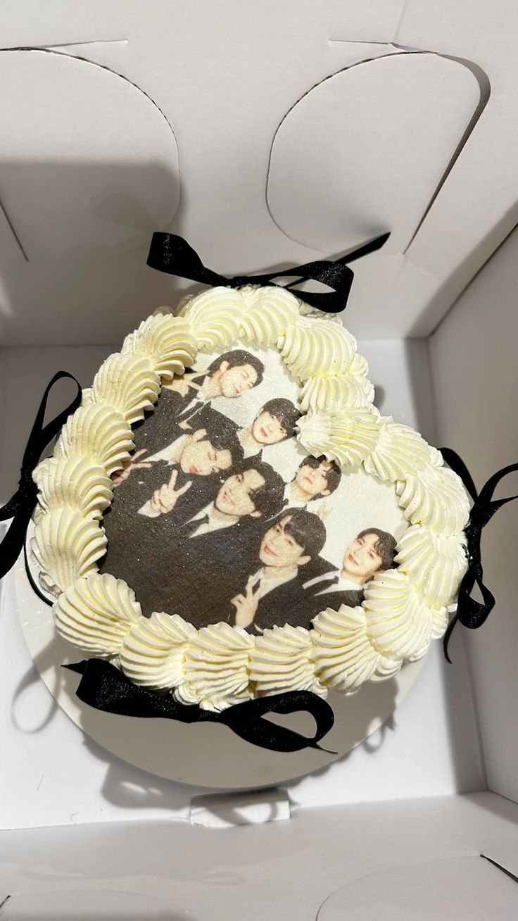 a cake with the beatles on it is in a white box and has black ribbon