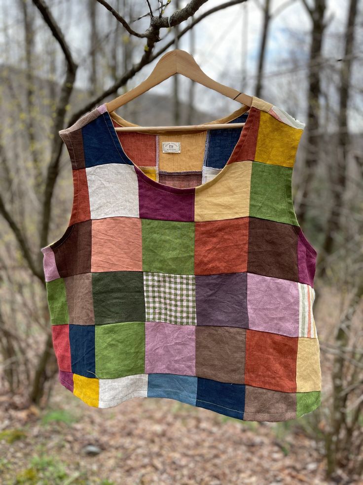 a multicolored patchwork shirt hanging from a tree