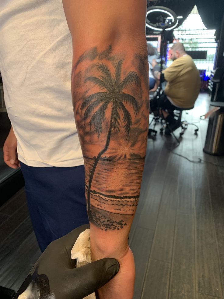 a man with a palm tree tattoo on his arm