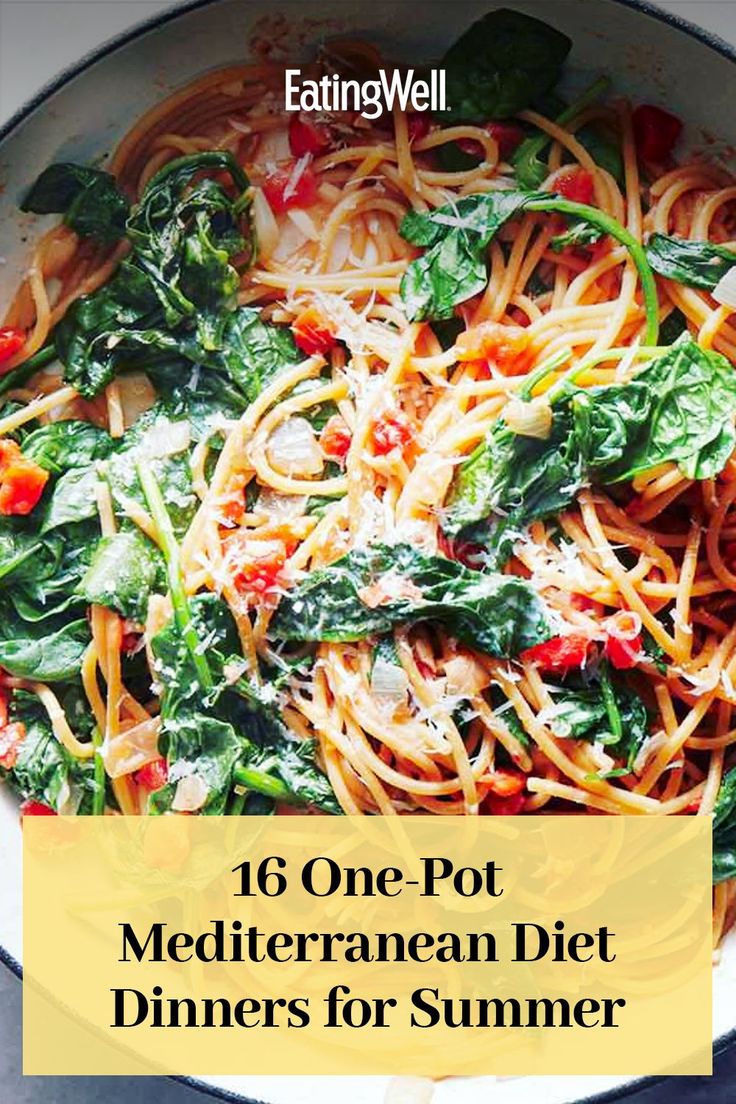 a bowl filled with pasta and spinach on top of a table