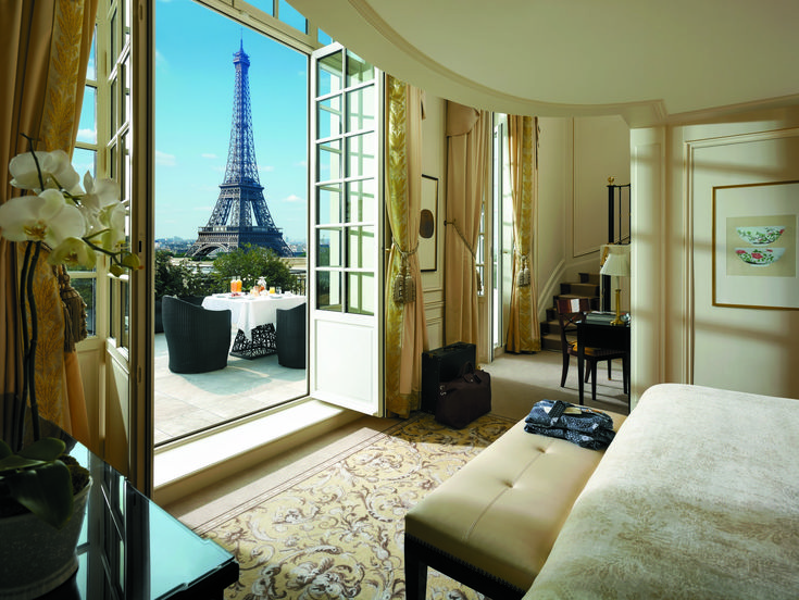 a bedroom with a view of the eiffel tower from it's window