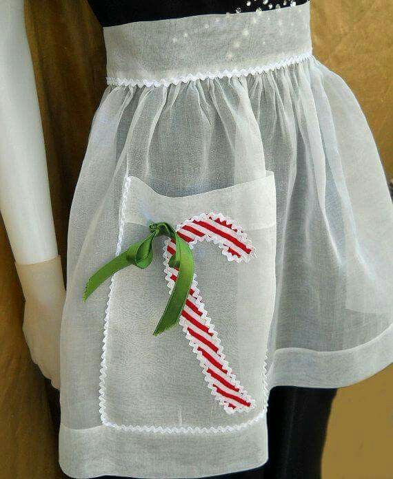 a white dress with a candy cane on the front and green ribbon at the bottom