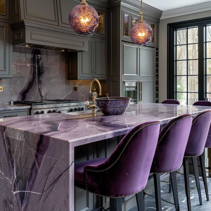 a kitchen with marble counter tops and purple chairs in front of an island that has lights hanging from it