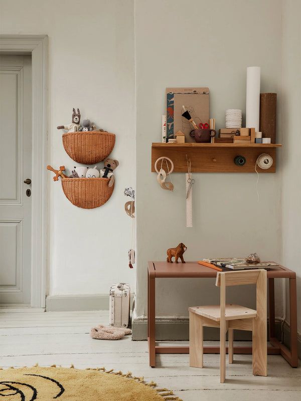 a child's room with toys and decor on the wall, including a desk